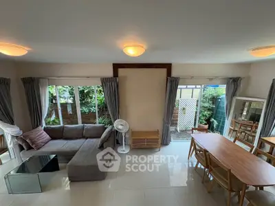 Spacious living room with modern furniture and garden view, perfect for family gatherings.