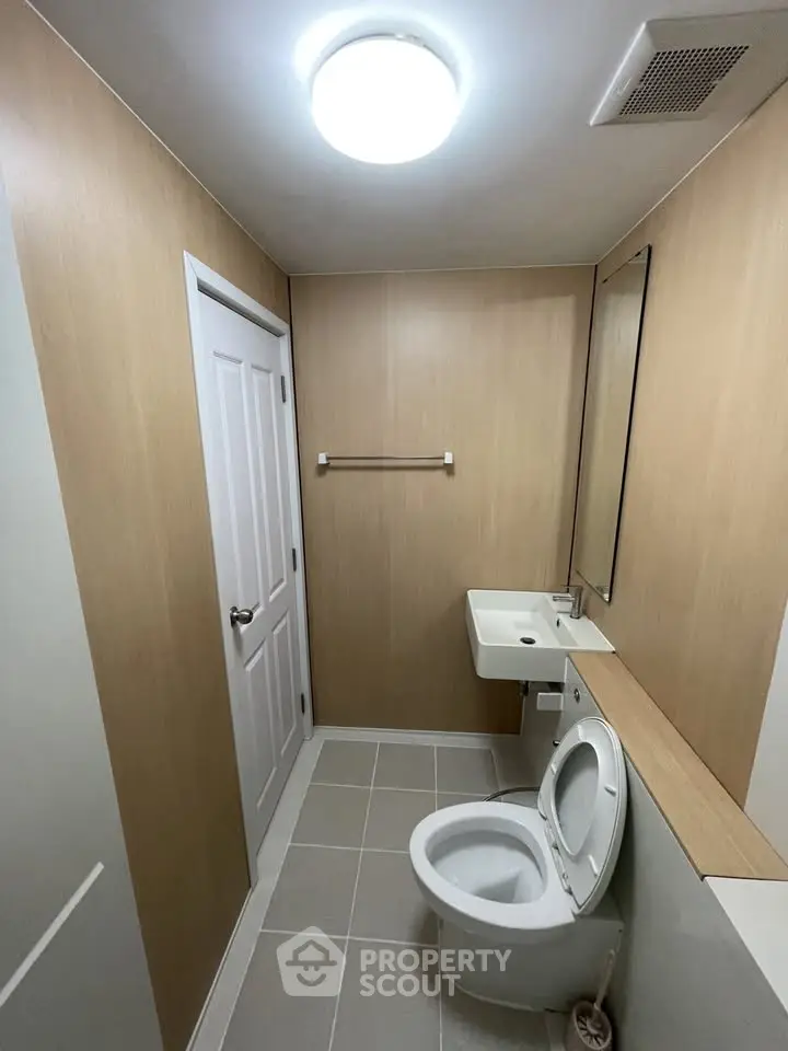 Modern minimalist bathroom with sleek fixtures and wood paneling