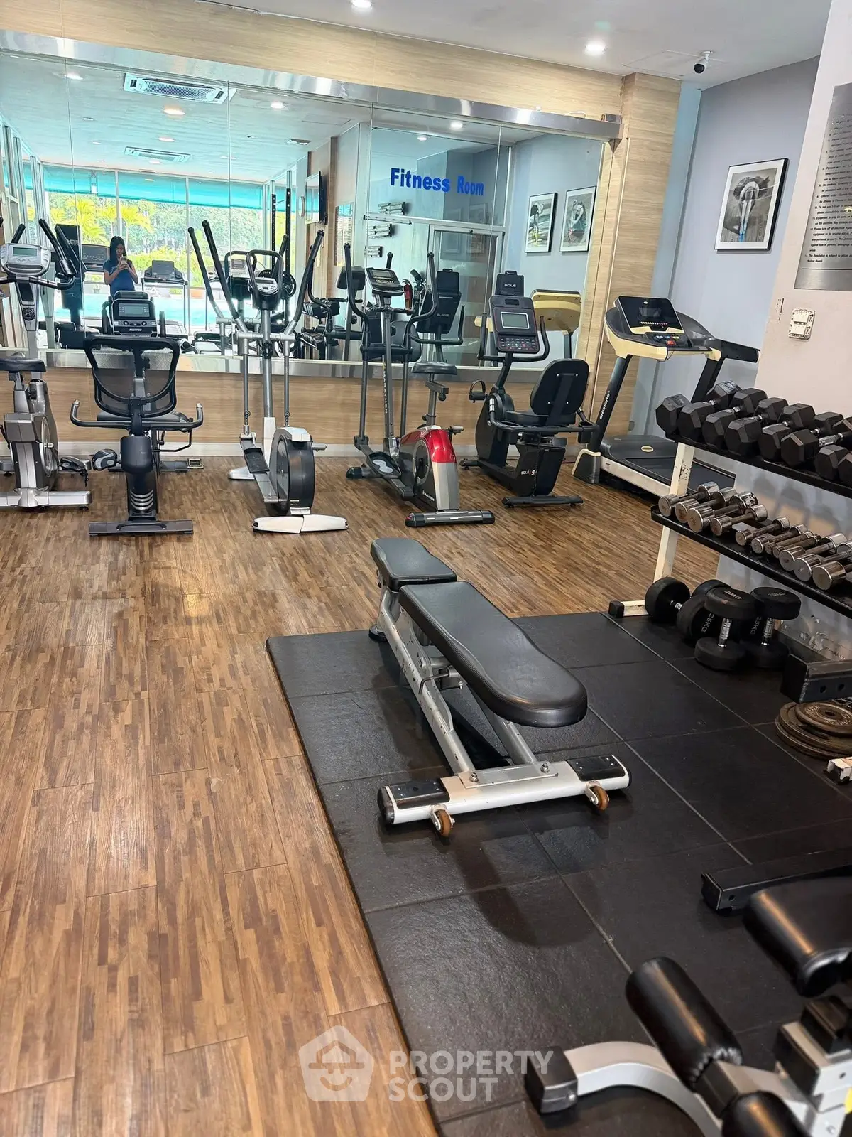 Modern fitness room with state-of-the-art gym equipment and wooden flooring.