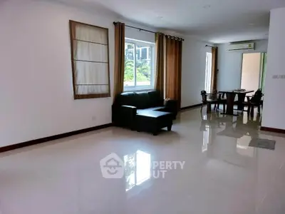 Spacious living room with modern furniture and large windows offering natural light.