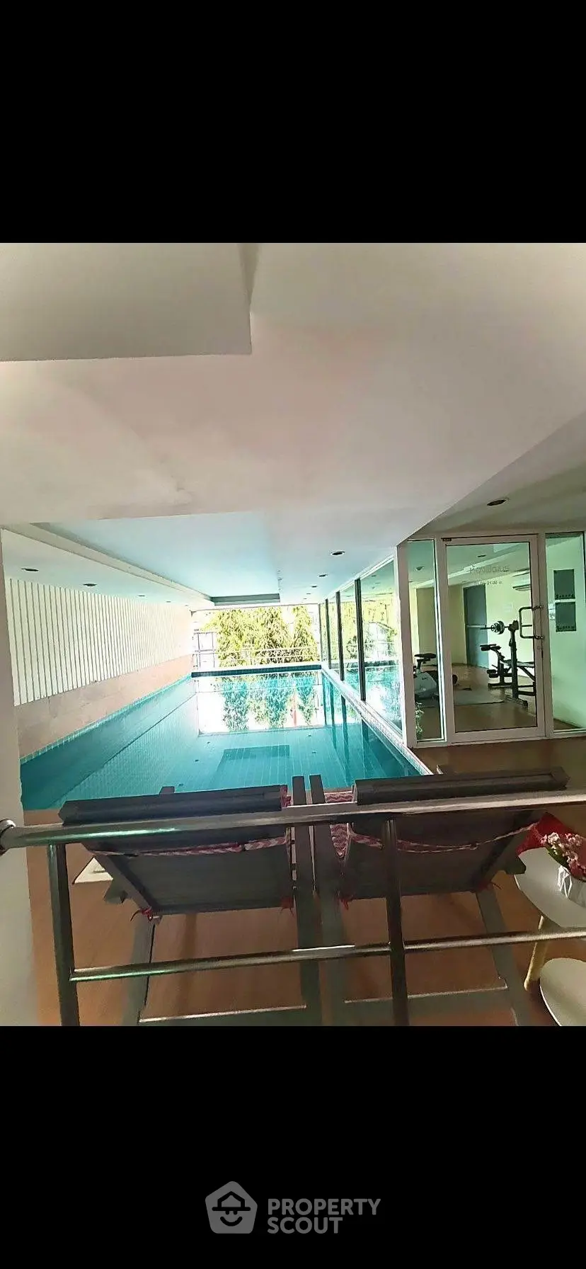 Luxurious indoor pool with gym view in modern residential building
