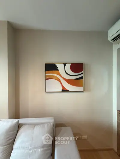 Modern living room with abstract art and sleek air conditioning unit