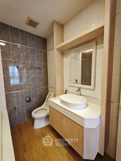 Modern bathroom with wooden flooring and sleek fixtures