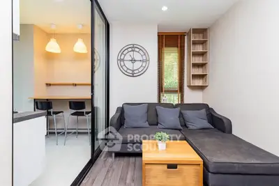 Modern living room with stylish decor and open layout, featuring a cozy sofa and natural light.
