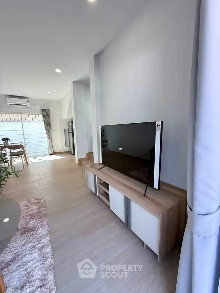Modern living room with sleek TV setup and natural light