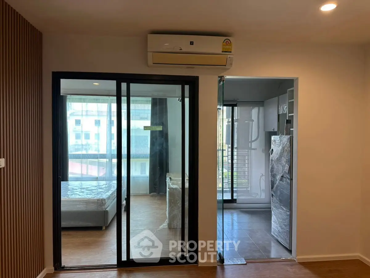 Modern apartment interior with sliding glass doors and air conditioning unit.