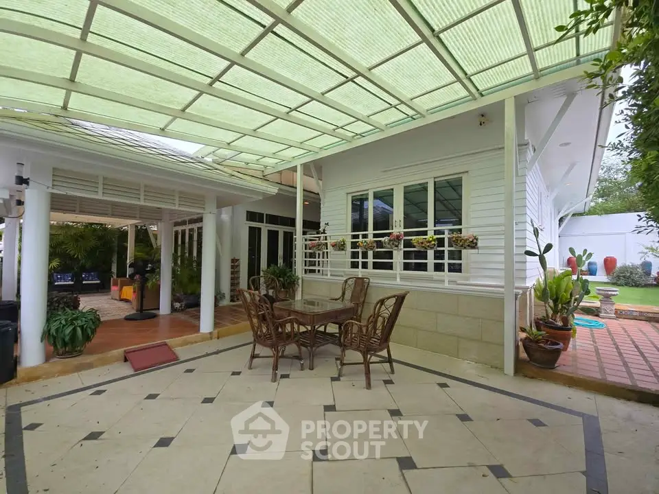 Charming patio with elegant outdoor furniture and lush garden view, perfect for relaxation and entertaining.