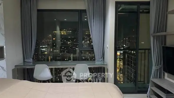 Modern bedroom with city view, featuring large windows and stylish decor.