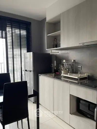 Modern kitchen with sleek cabinetry and stainless steel appliances in a stylish apartment.