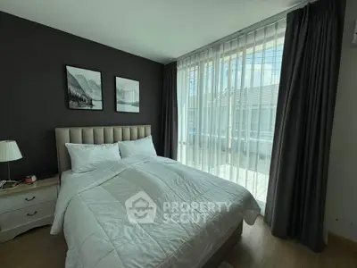 Modern bedroom with large windows and elegant decor in a stylish apartment.