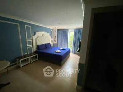 Spacious bedroom with elegant blue decor and natural light