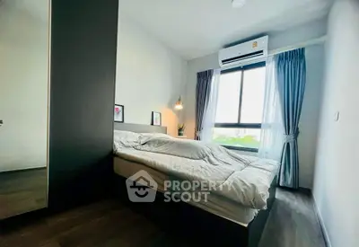 Modern bedroom with large window and air conditioning, featuring stylish decor and natural light.