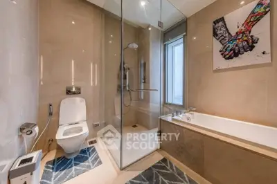 Luxurious modern bathroom with glass shower and bathtub, featuring elegant decor and natural light.