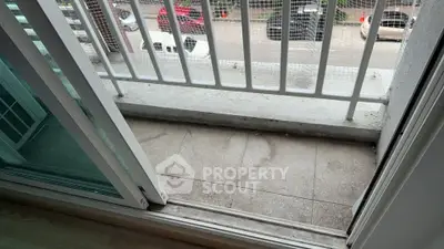 Small balcony with sliding glass door overlooking street view