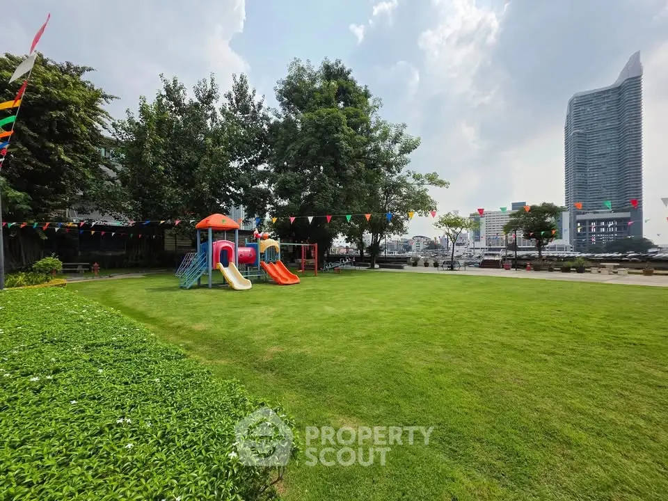 Spacious garden with playground and cityscape view, ideal for family living.