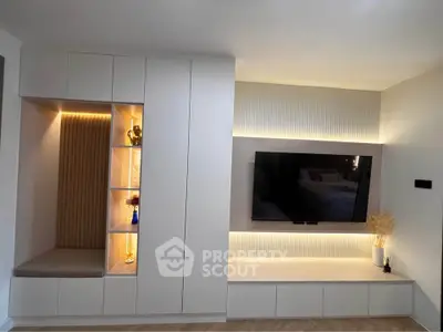 Modern living room with built-in storage and TV unit, featuring ambient lighting and sleek design.