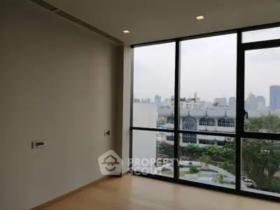 Spacious room with large windows offering a stunning city view, perfect for modern living.