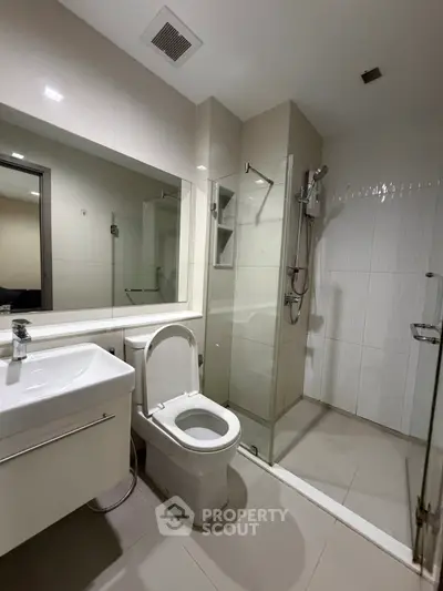 Modern bathroom with glass shower and sleek fixtures in a contemporary apartment.