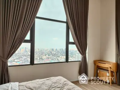 Cozy bedroom with a large window offering a panoramic city view, complemented by elegant drapery and a comfortable bed.