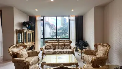 Luxurious living room with elegant gold furniture and large window view