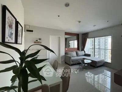 Modern living room with large windows and stylish decor in a high-rise apartment.