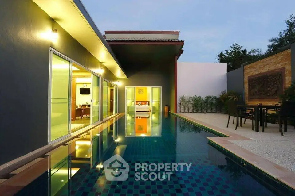 Luxurious modern villa with private pool and elegant outdoor seating area at dusk.