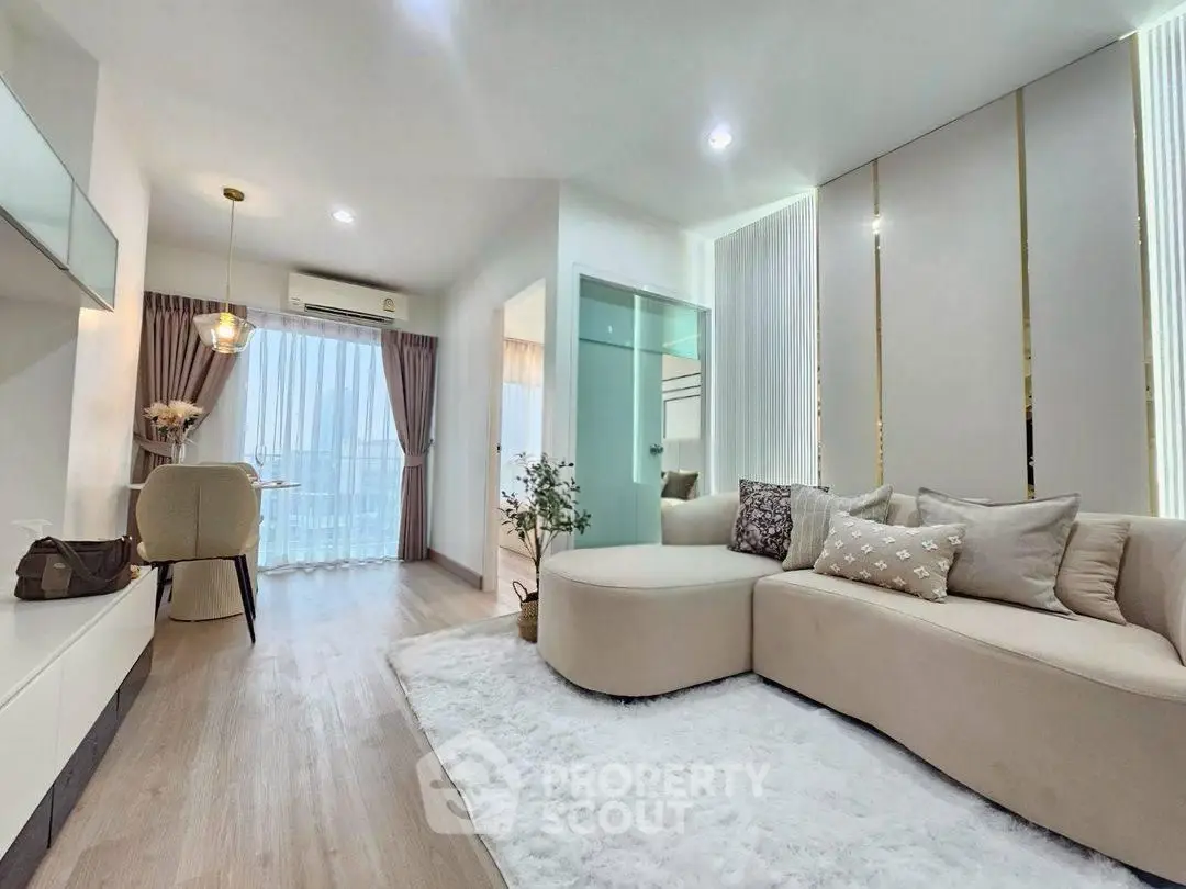 Modern living room with elegant decor and natural light, featuring cozy seating and stylish dining area.