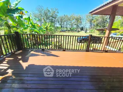 Spacious wooden deck with scenic garden view, perfect for outdoor relaxation and entertainment.