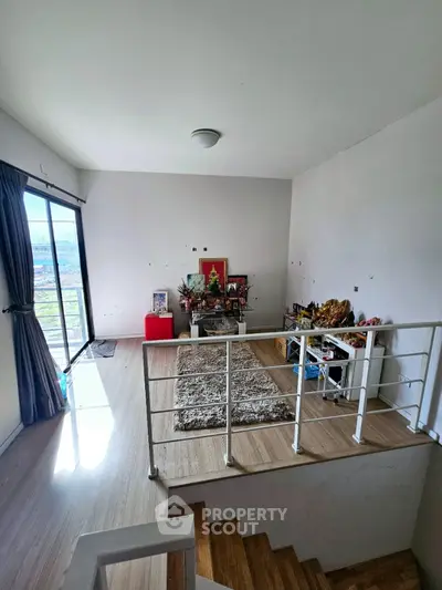 Spacious living area with wooden flooring and balcony access