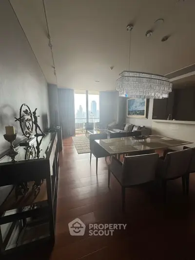 Luxurious living room with elegant chandelier and city view, featuring modern decor and open layout.