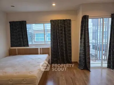 Spacious bedroom with large windows and balcony access in modern apartment