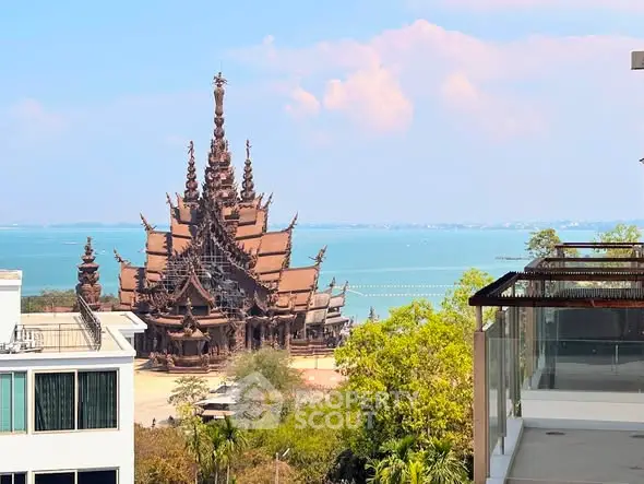 Stunning ocean view from modern balcony overlooking unique architectural landmark.