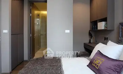 Modern bedroom with elegant decor and ensuite bathroom in luxury apartment.