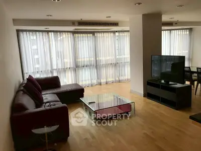 Spacious modern living room with large windows and sleek furniture