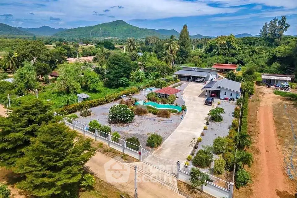 Stunning aerial view of a countryside property with pool and lush greenery, perfect for serene living.