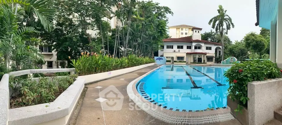 Luxurious residential pool area with lush greenery and elegant architecture