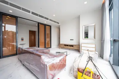 Spacious modern living room with large windows and stylish furniture in a luxury apartment.