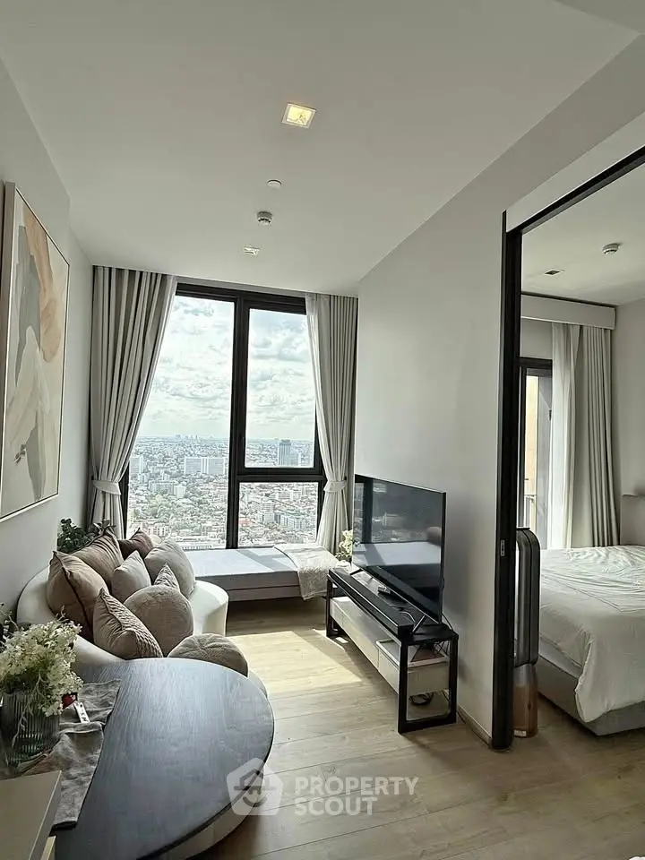 Modern living room with stunning city view, cozy seating, and elegant decor in a high-rise apartment.