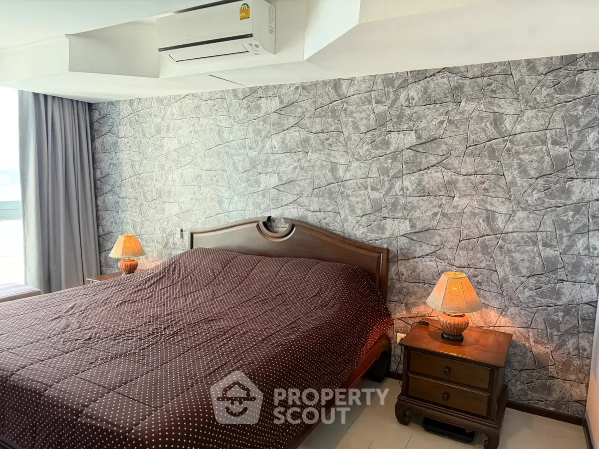 Spacious bedroom with stylish stone accent wall and cozy lighting