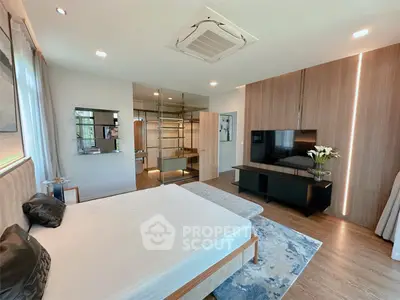 Luxurious modern bedroom with stylish decor and large TV, perfect for relaxation.