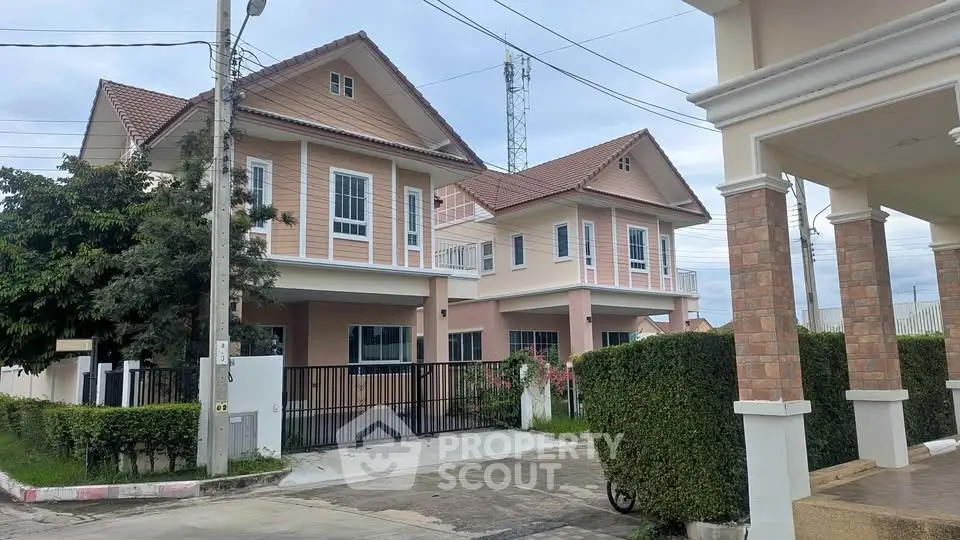 Charming suburban house with pink exterior and lush greenery, perfect for family living.