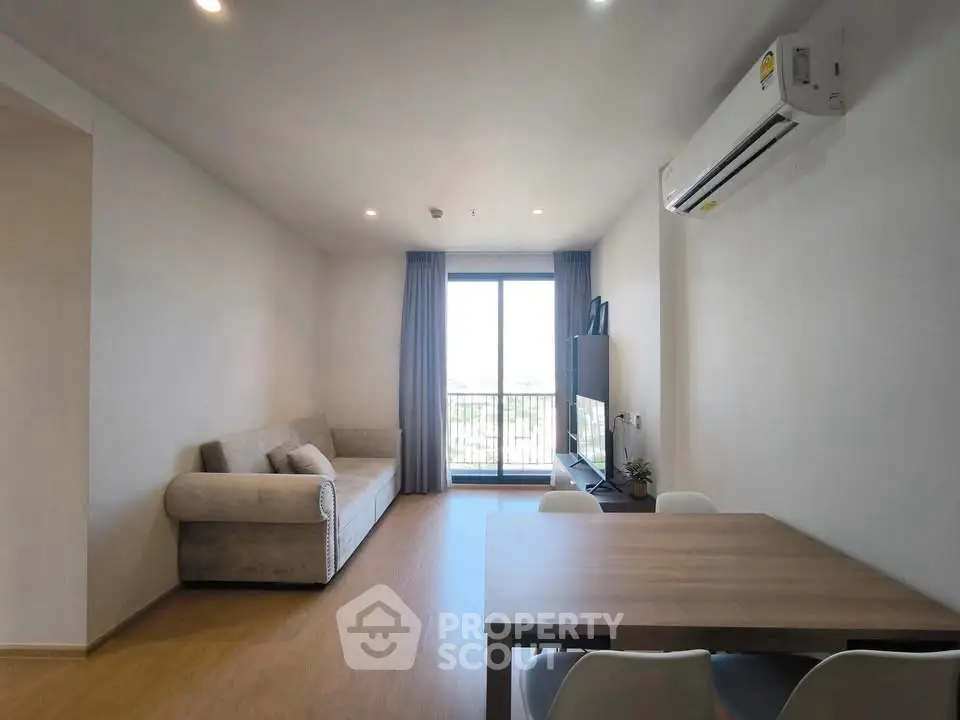 Modern living room with balcony, cozy sofa, and dining area in a bright apartment.