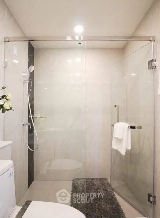 Modern bathroom with glass shower enclosure and elegant tile design.