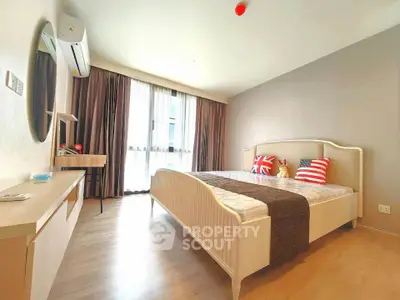 Spacious bedroom with modern decor and large window for natural light