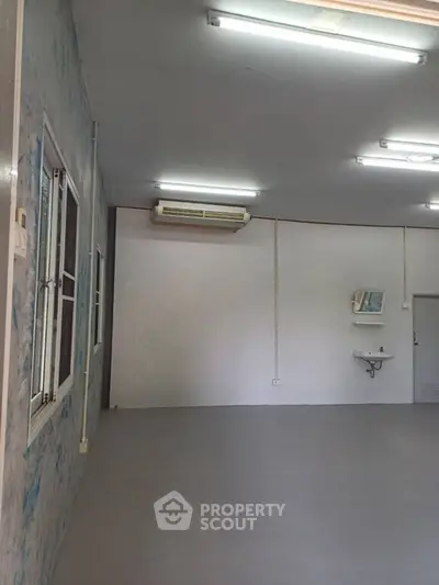 Spacious interior room with air conditioning and sink, ideal for versatile use.