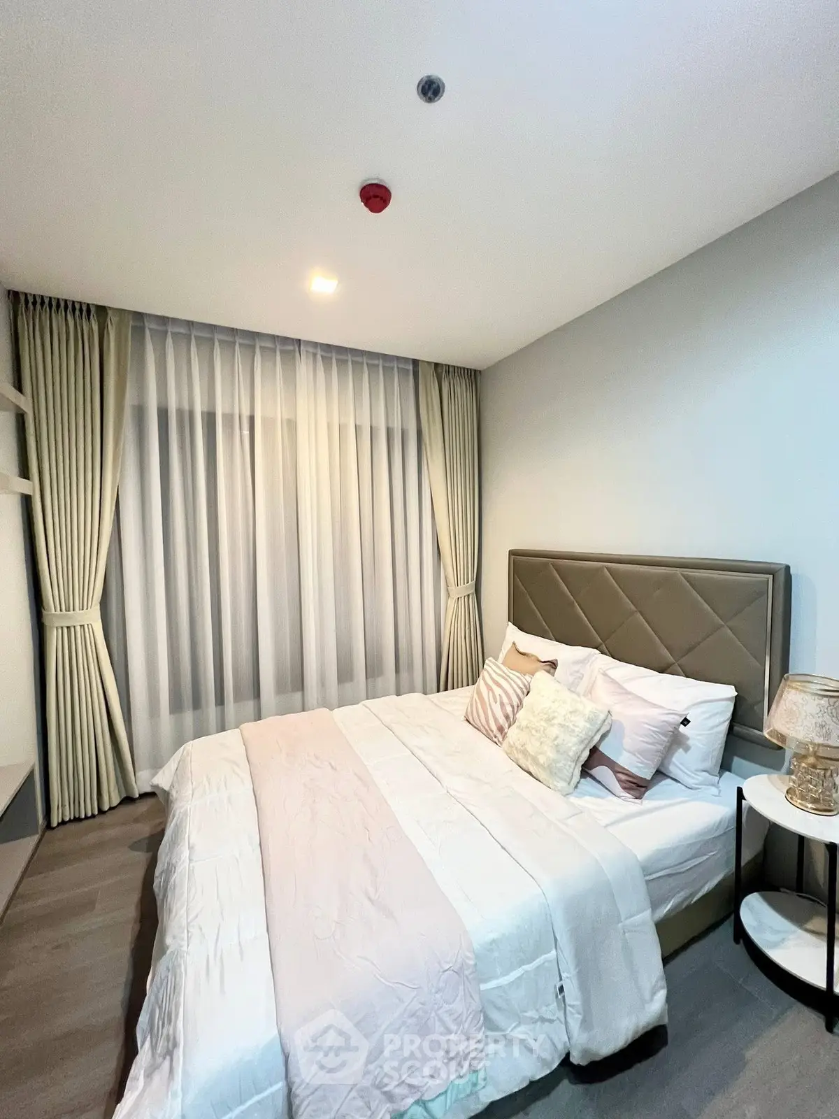 Modern bedroom with elegant decor and cozy ambiance, featuring a plush bed and stylish curtains.