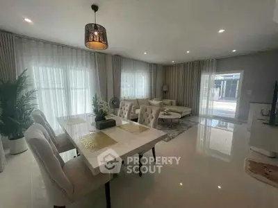 Elegant modern living room with dining area, featuring plush seating and abundant natural light.