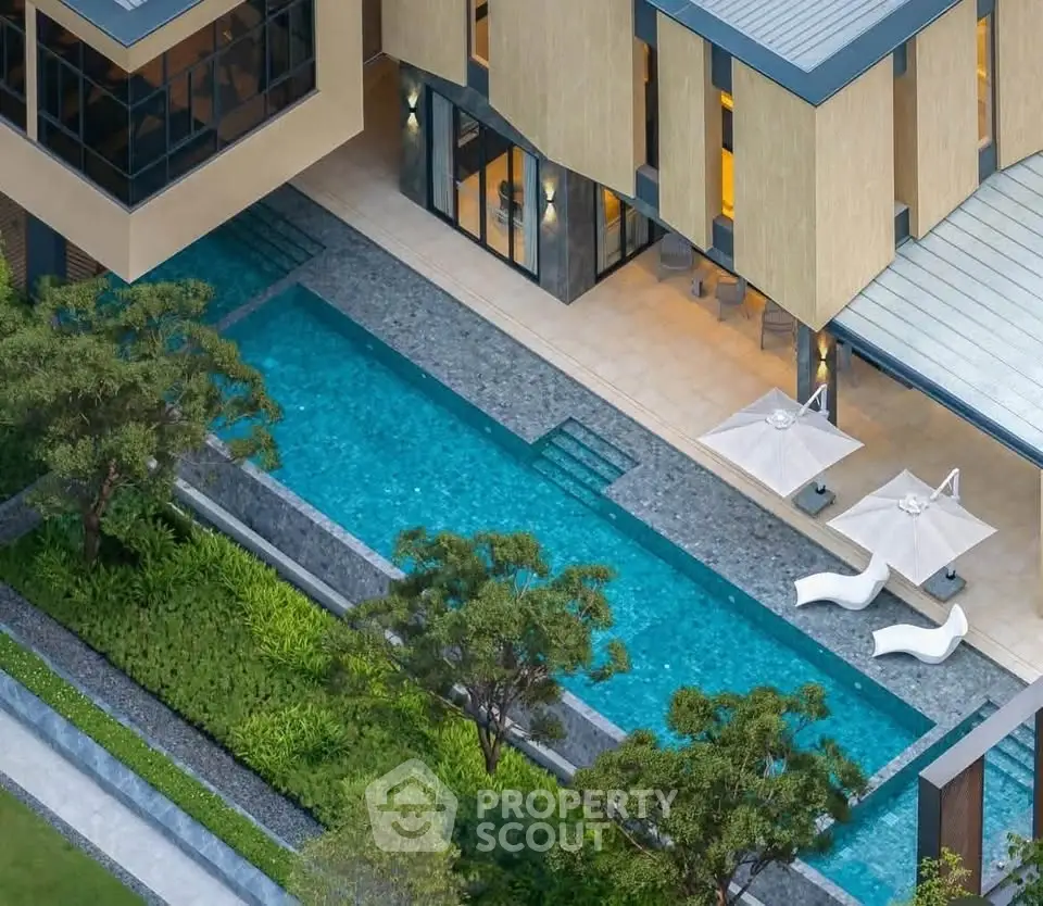 Luxurious modern home with stunning pool and lush garden, perfect for relaxation and entertainment.