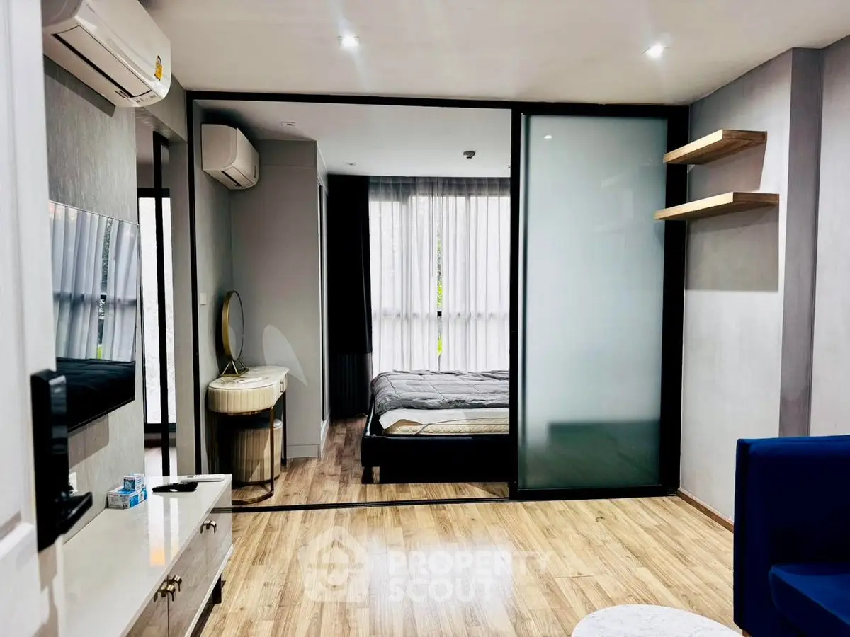 Modern studio apartment with sliding glass doors and wooden flooring