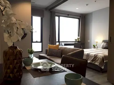 Modern open-plan living room and bedroom with stylish decor and natural light